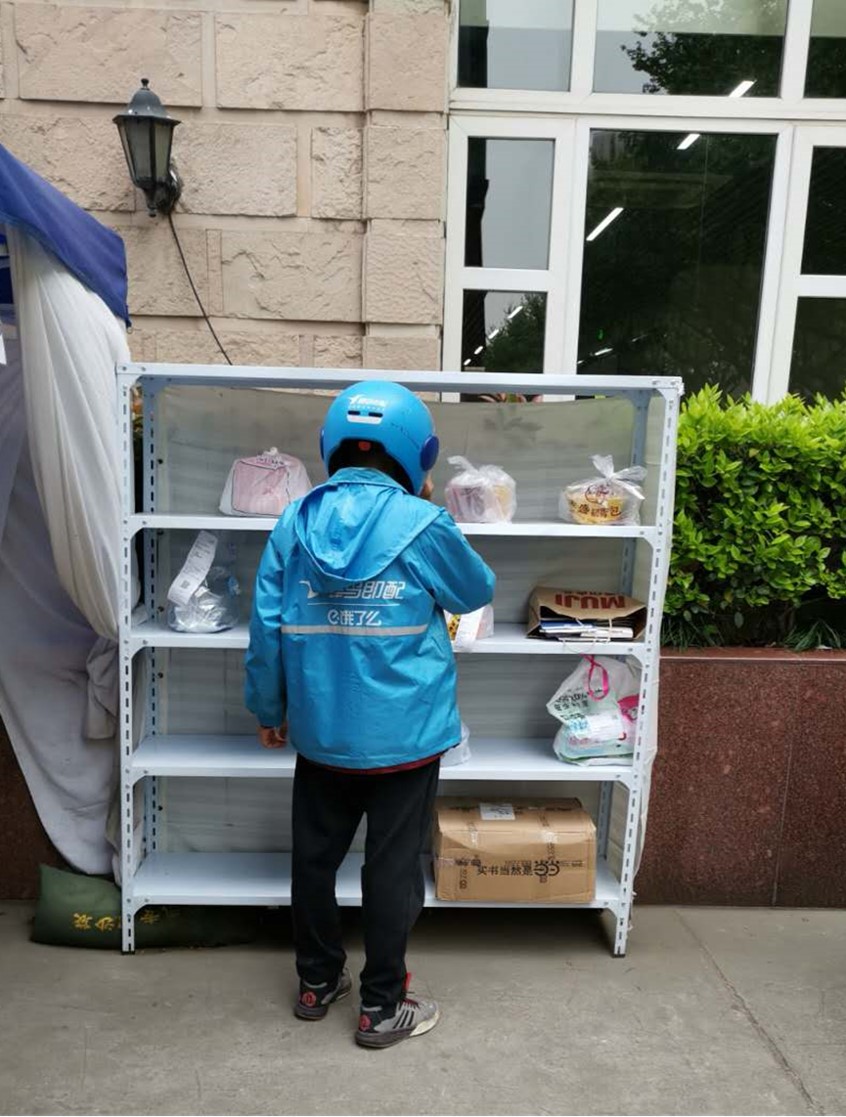 A delivery driver picks up food parcels for delivery during the coronavirus outbreak in China