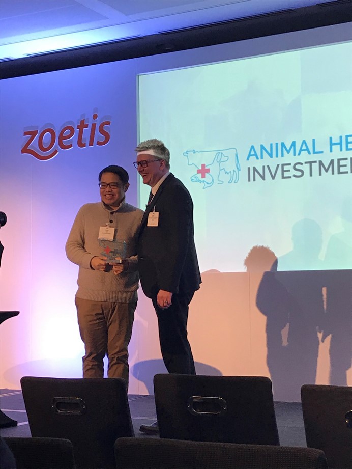 Zoetis Senior Vice President Jamie Brannan presents Amado Guloy, CEO and founder of Rex Animal Health, with the 2019 Animal Health Innovation Award.