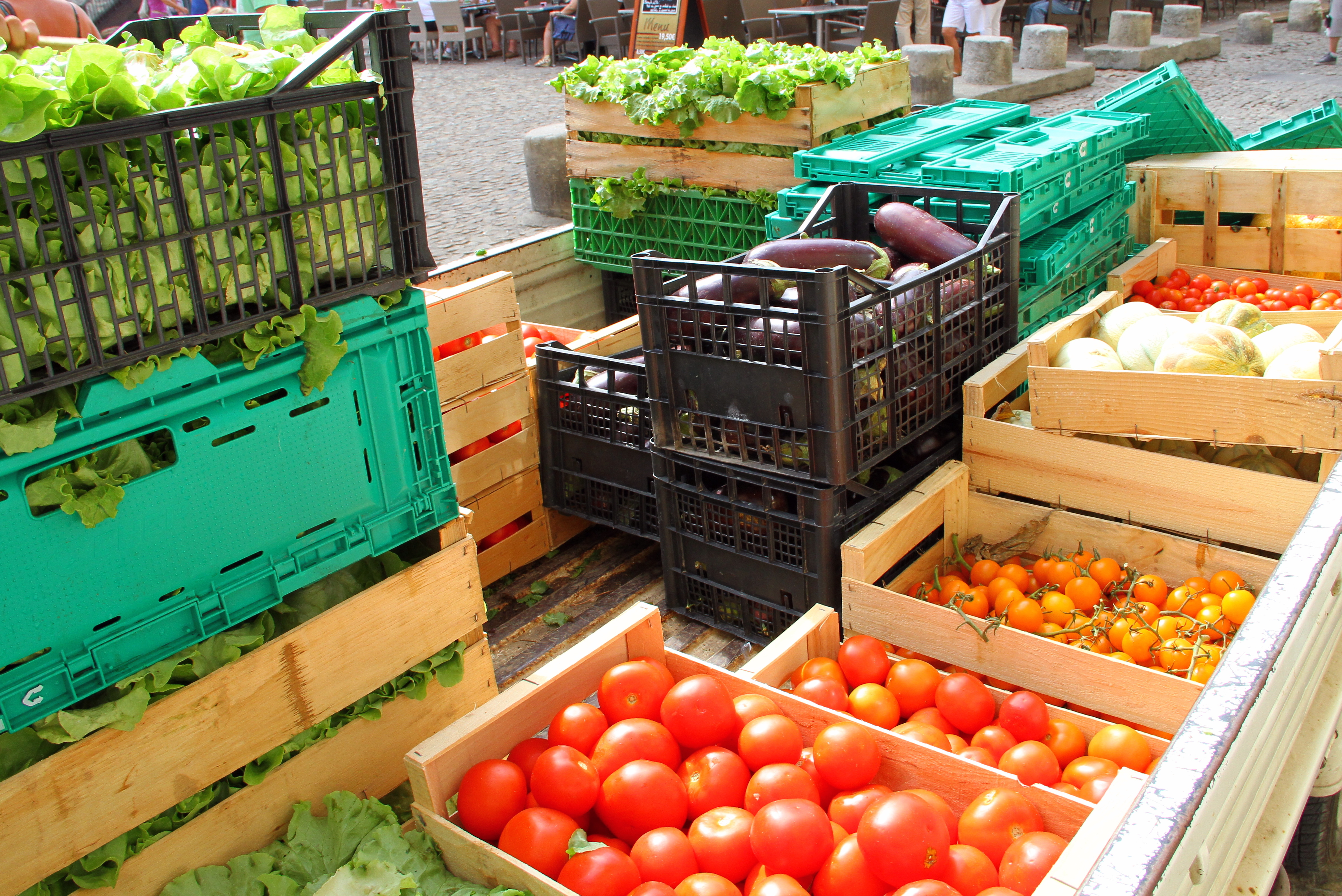 fresh fruit and vegetables stacked in crates outdoors