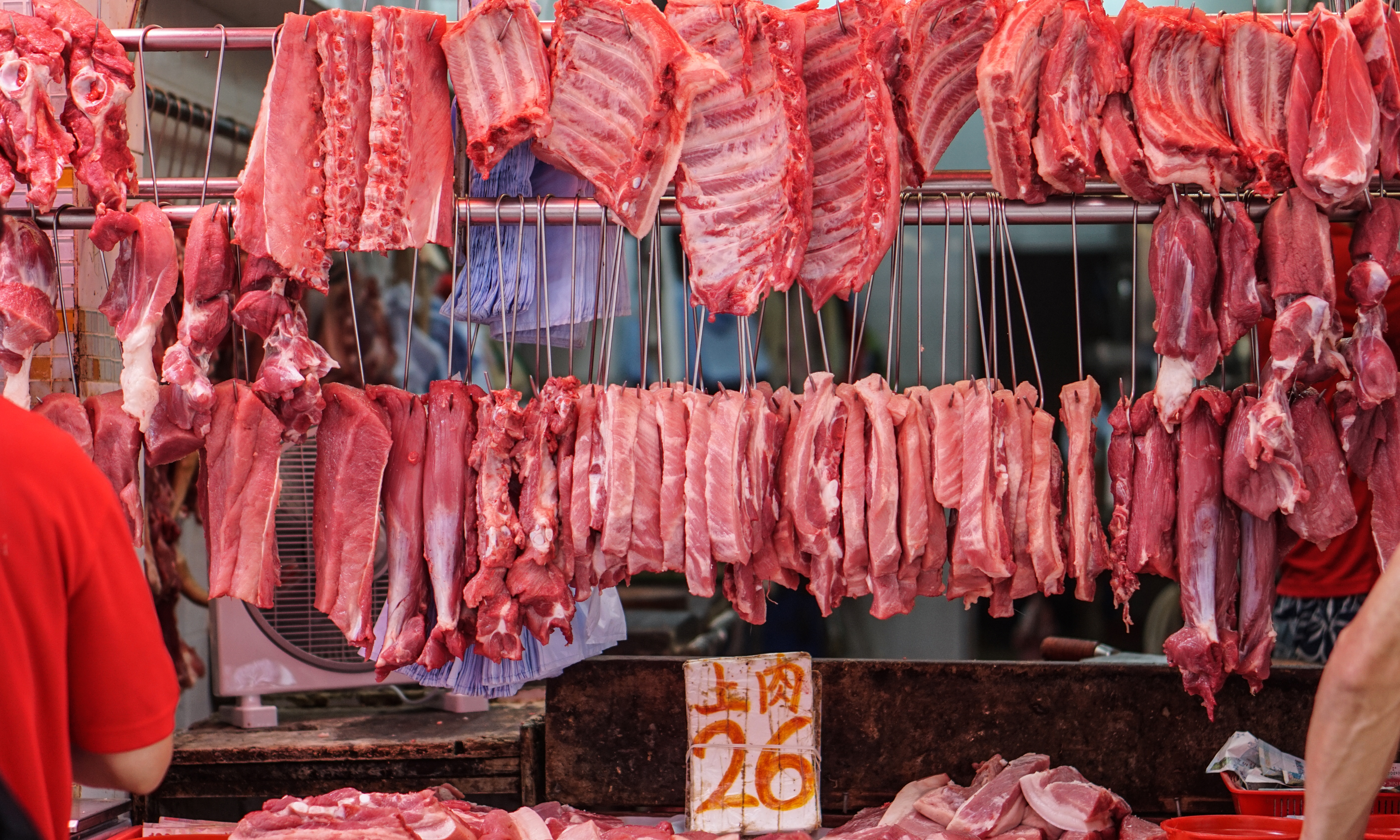 vendor sells pork at a wet market in China