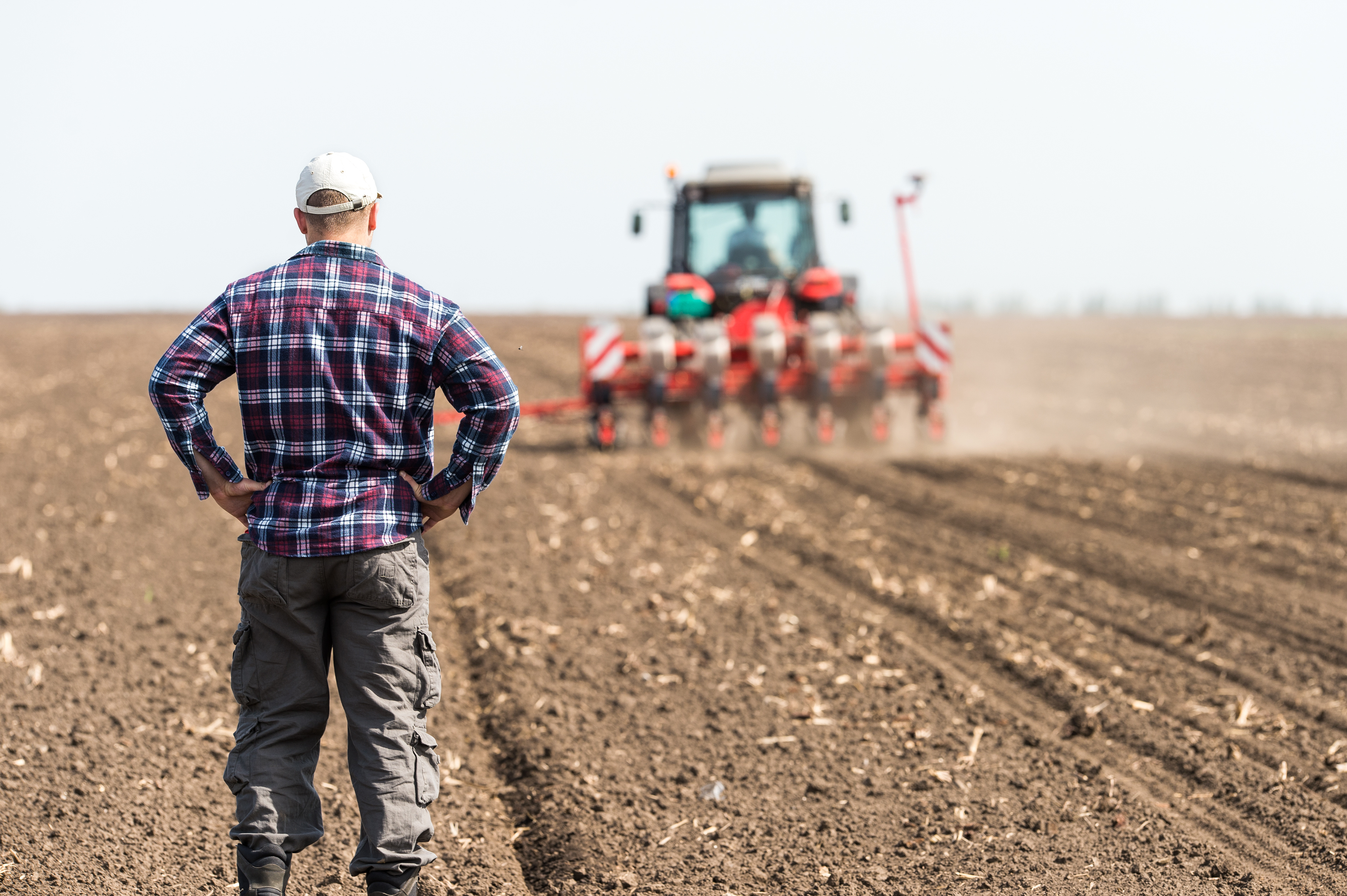 farmer standing outside watching the plough