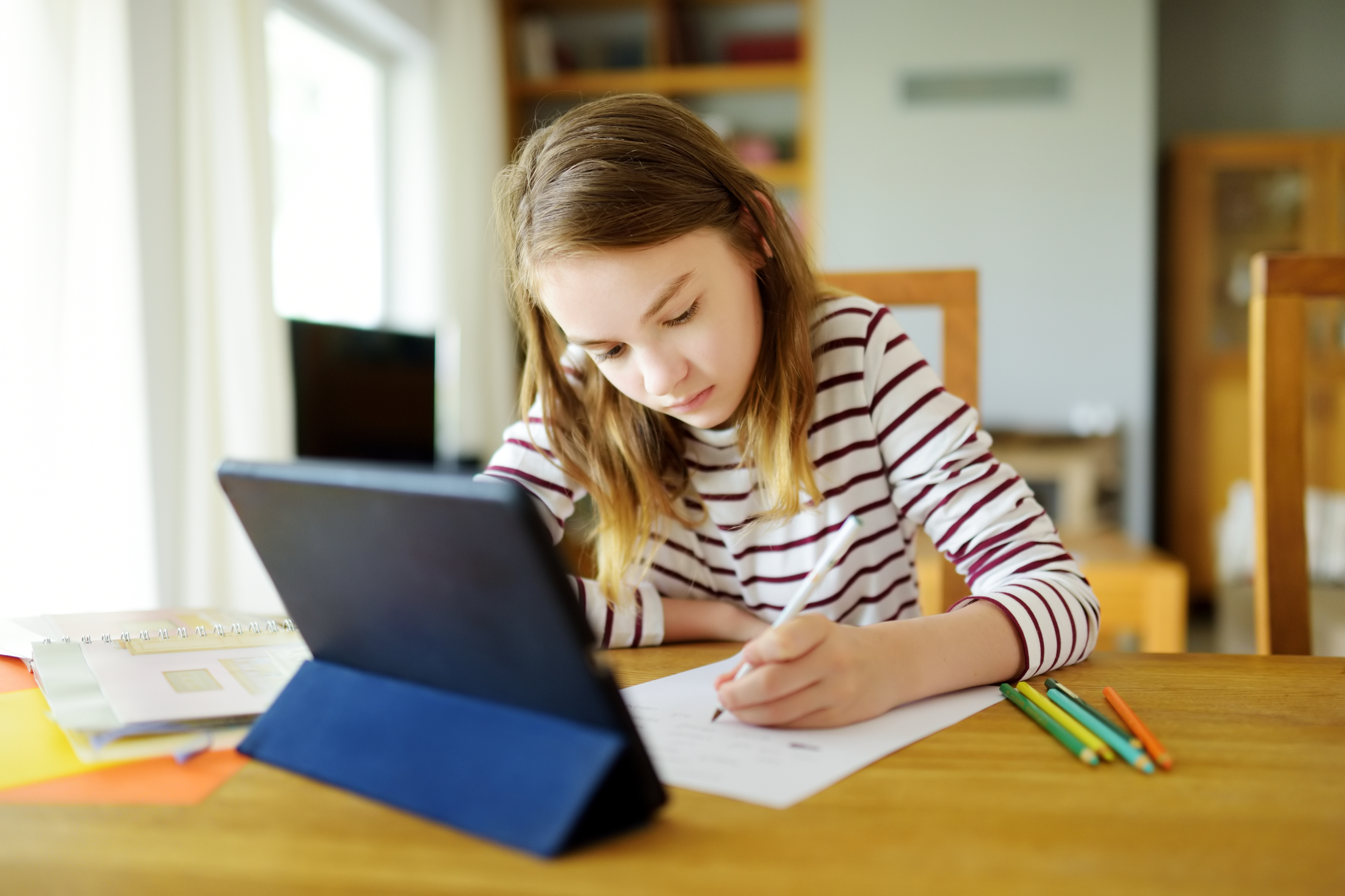 young girl doing distance learning with an ipad