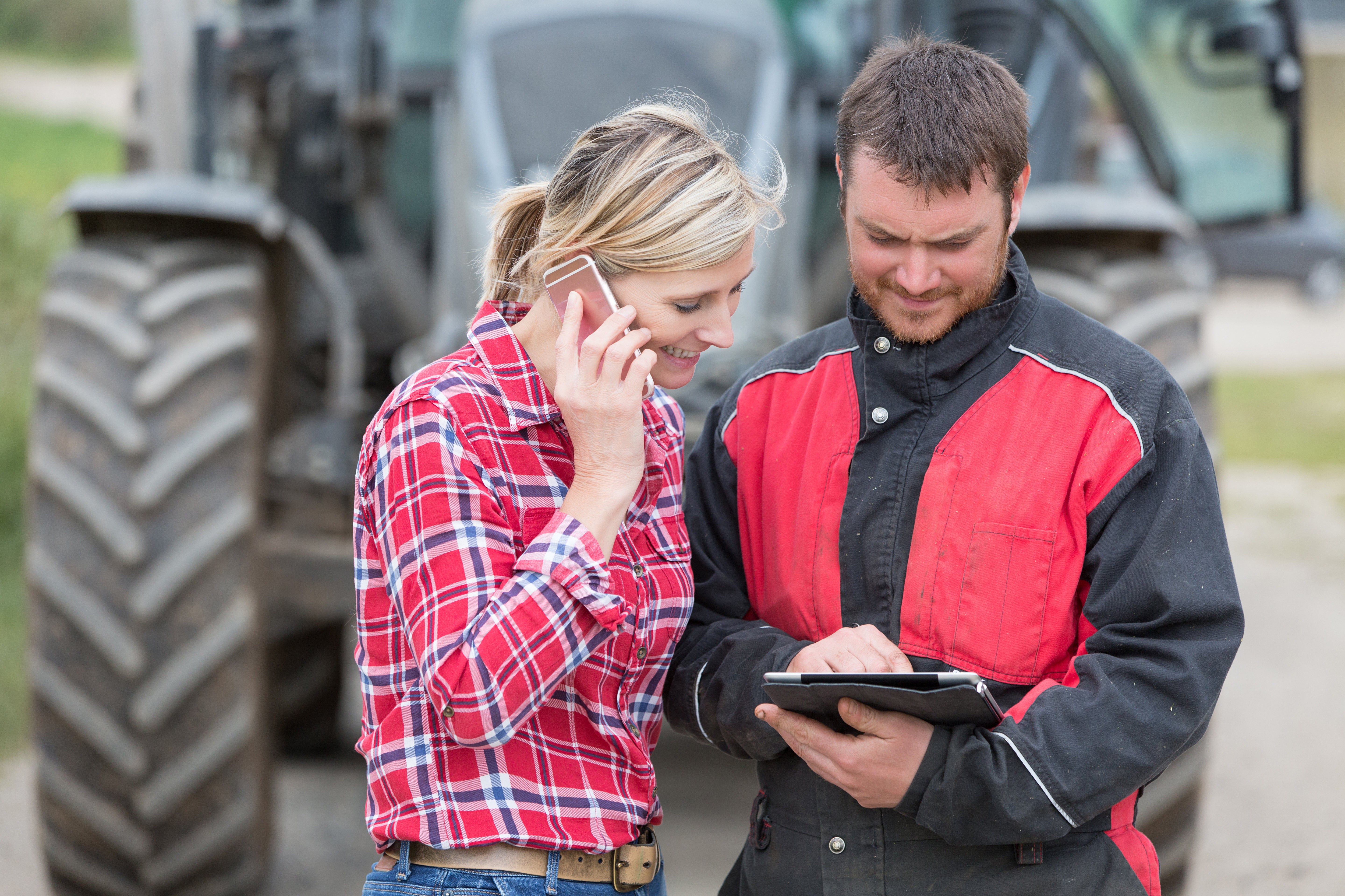 two farmers looking down at an ipad