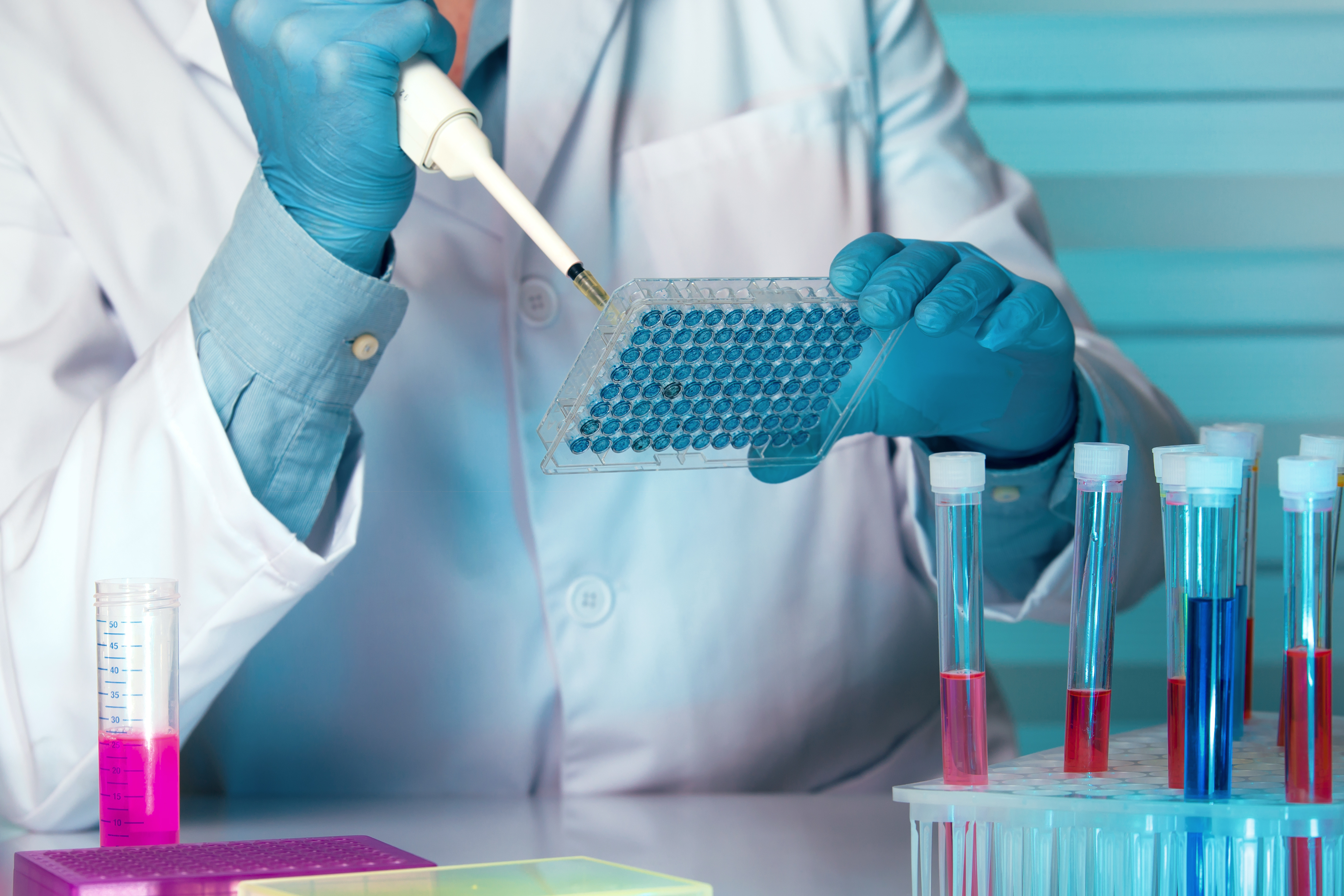 researcher pipettes fluid into a tray