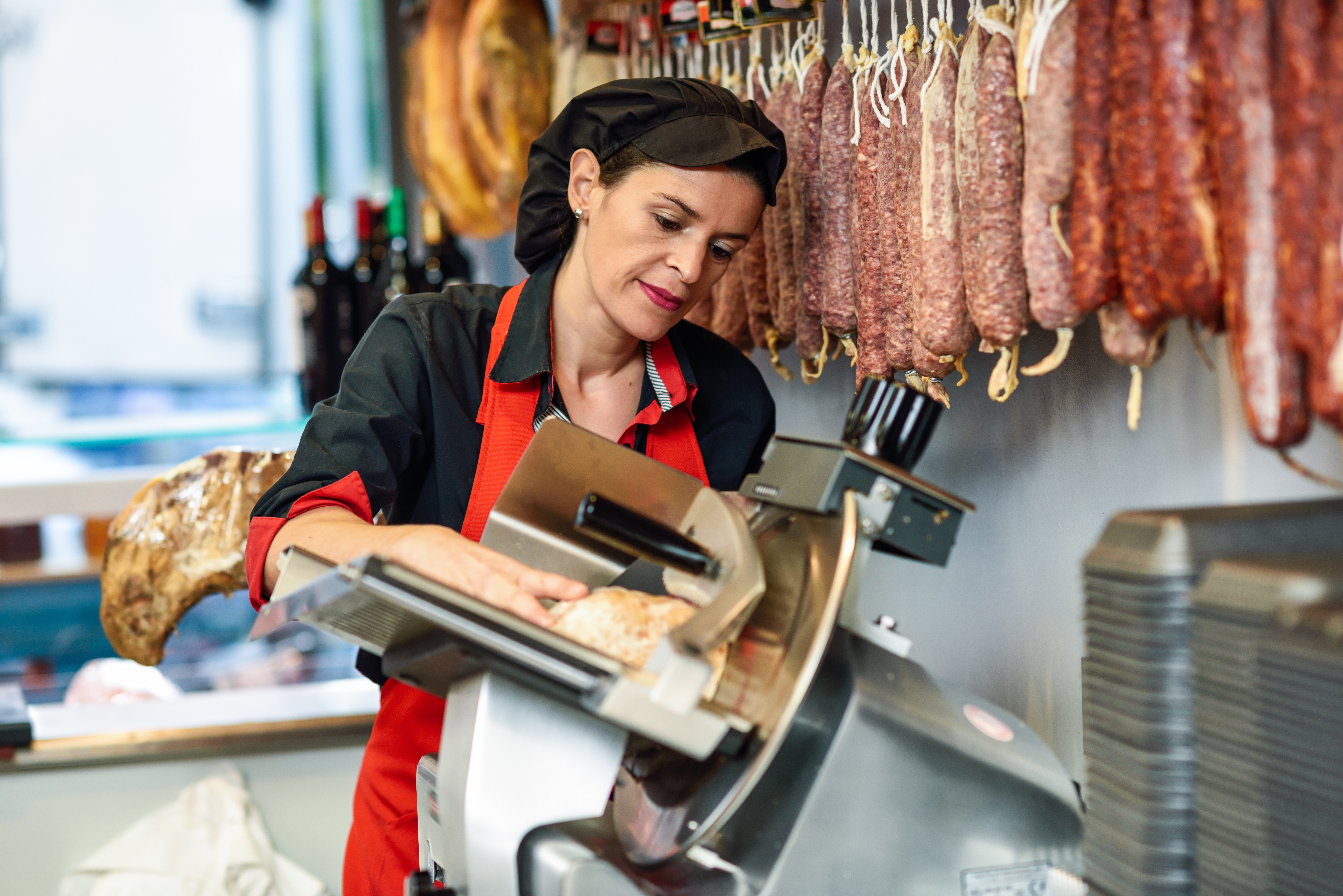 butcher slicing ham in a shop