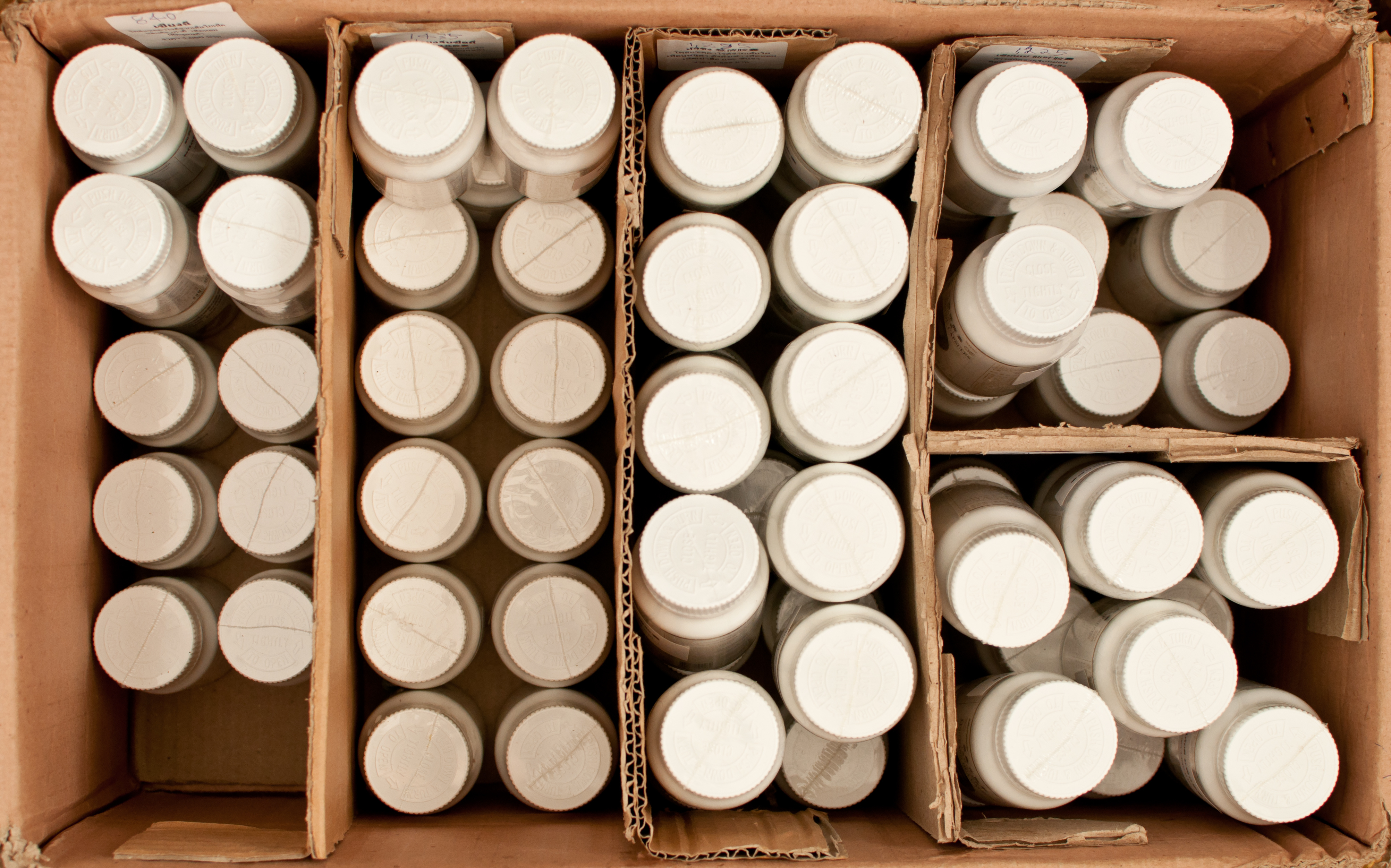 shampoo or pill bottles stored in a cadrboard box