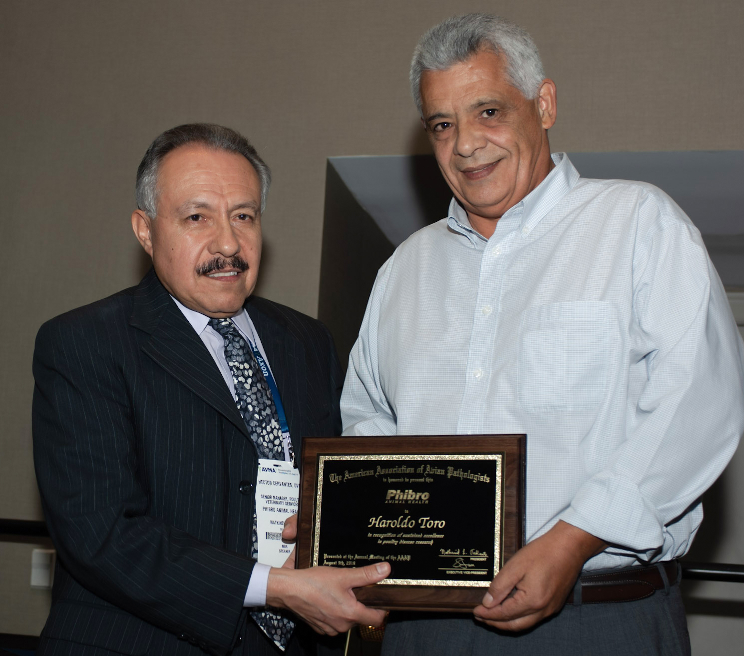 Dr. Haroldo Toro, right, Auburn University professor of avian diseases, receives the American Association of Avian Pathologists’ Phibro Animal Health Excellence in Poultry Research Award from Dr. Hector Cervantes, AAAP past president and Phibro representative.