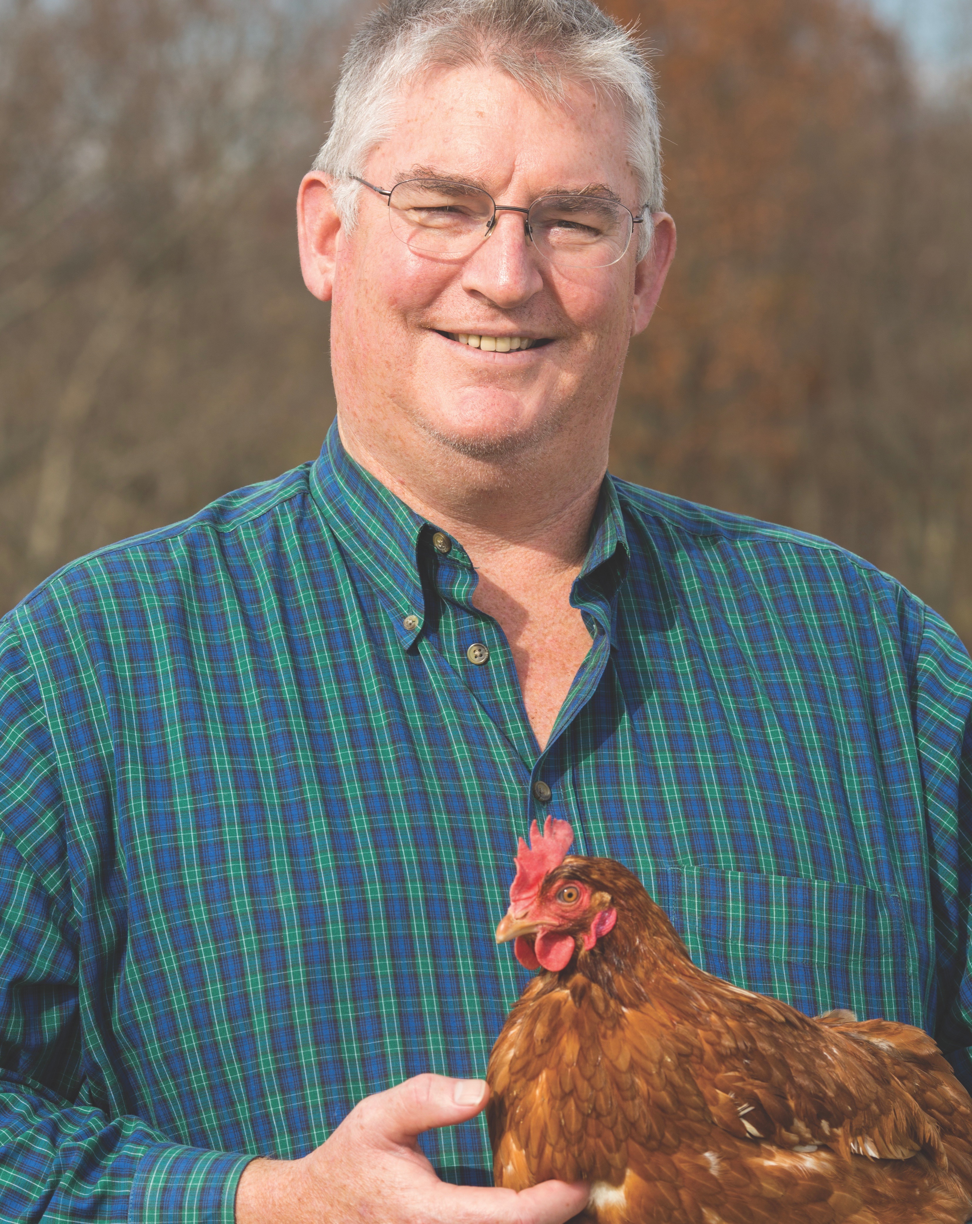 a man holds a chicken