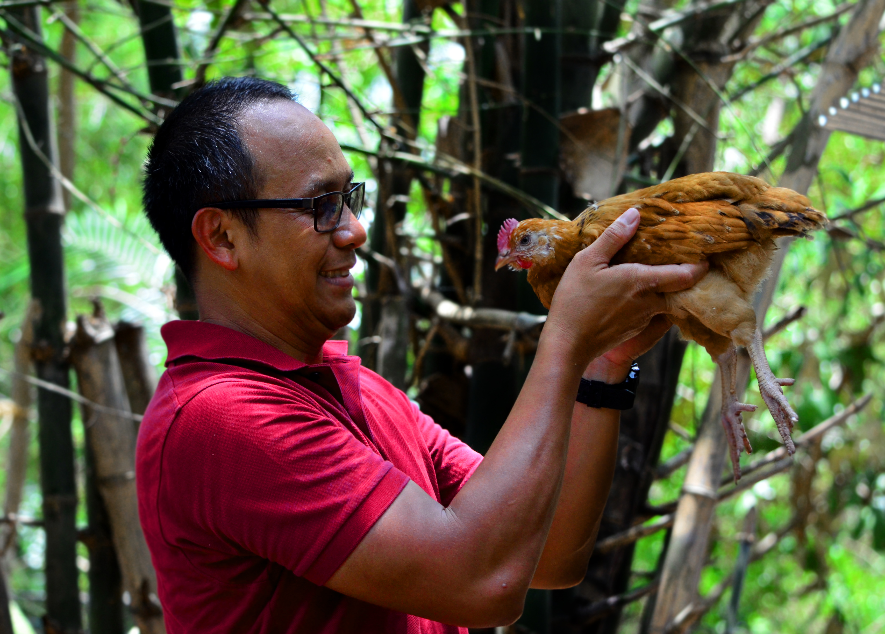 farmer holding chicken in front of his face