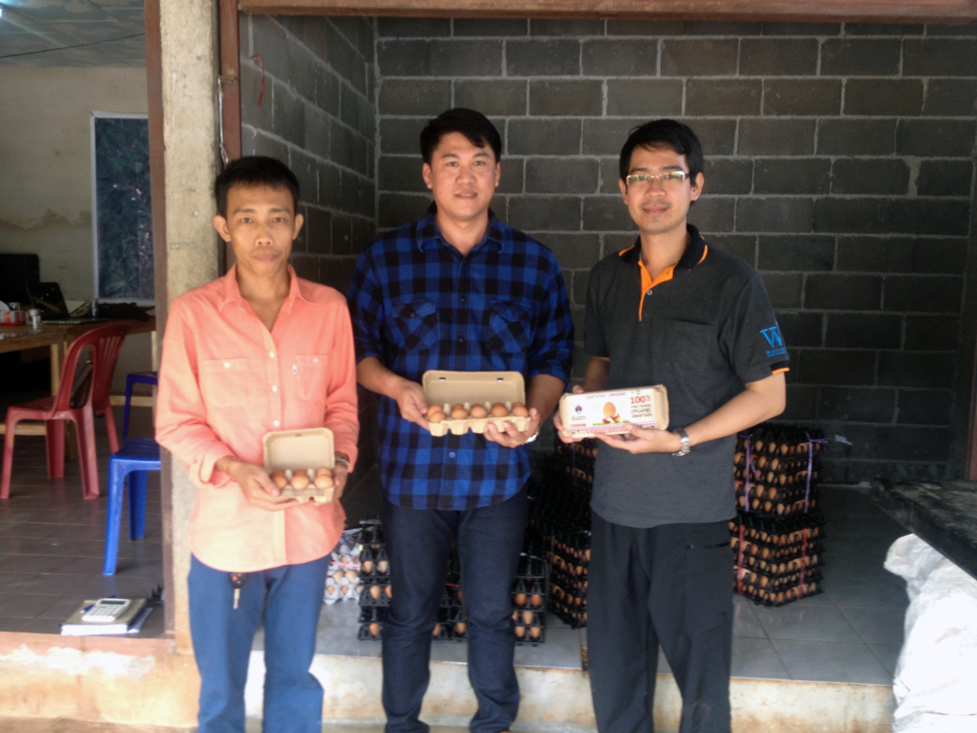 three men standing and holding eggs