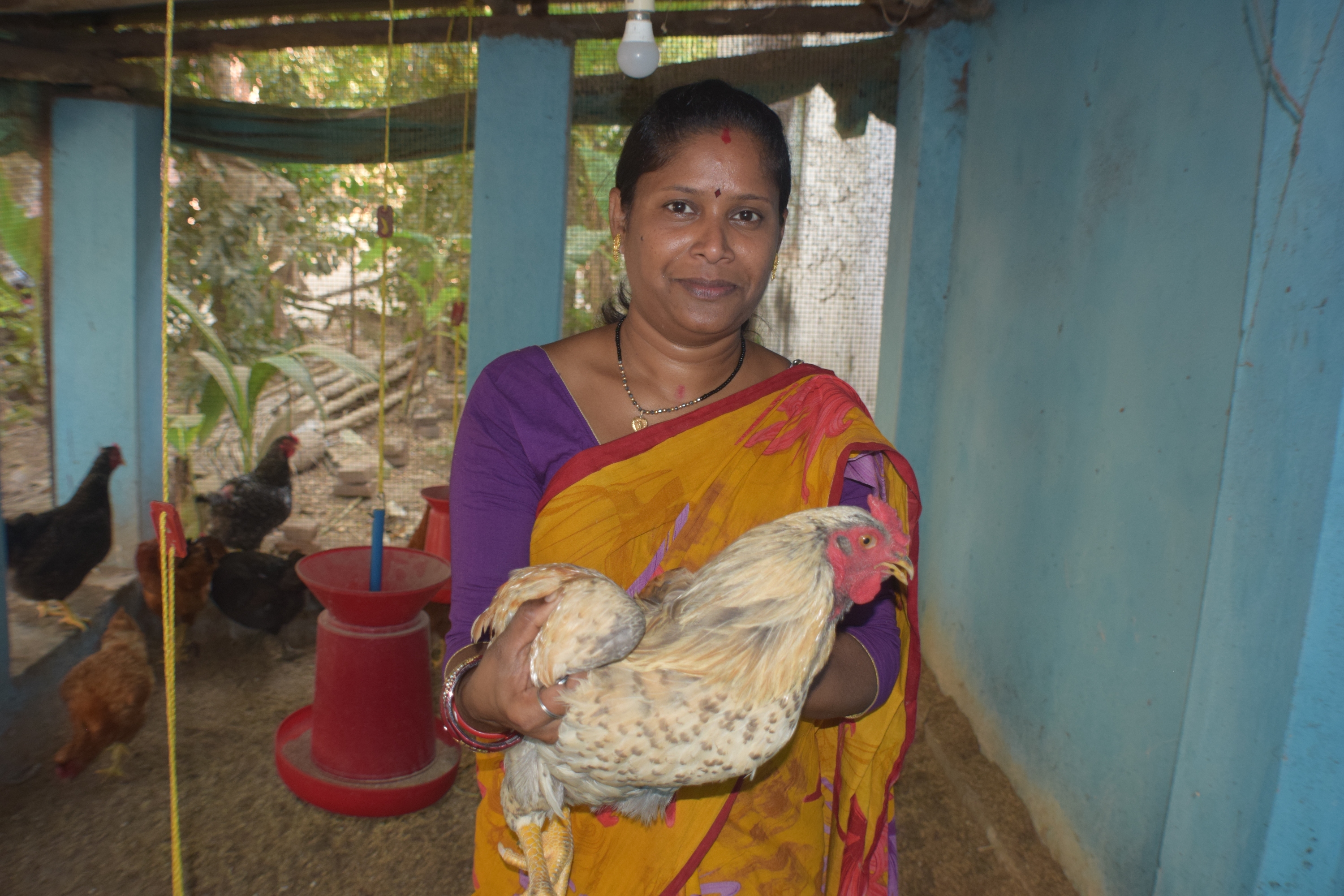 a women holds a chicken and smiles