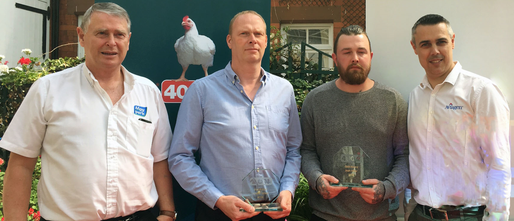 Four men stand with awards trophy