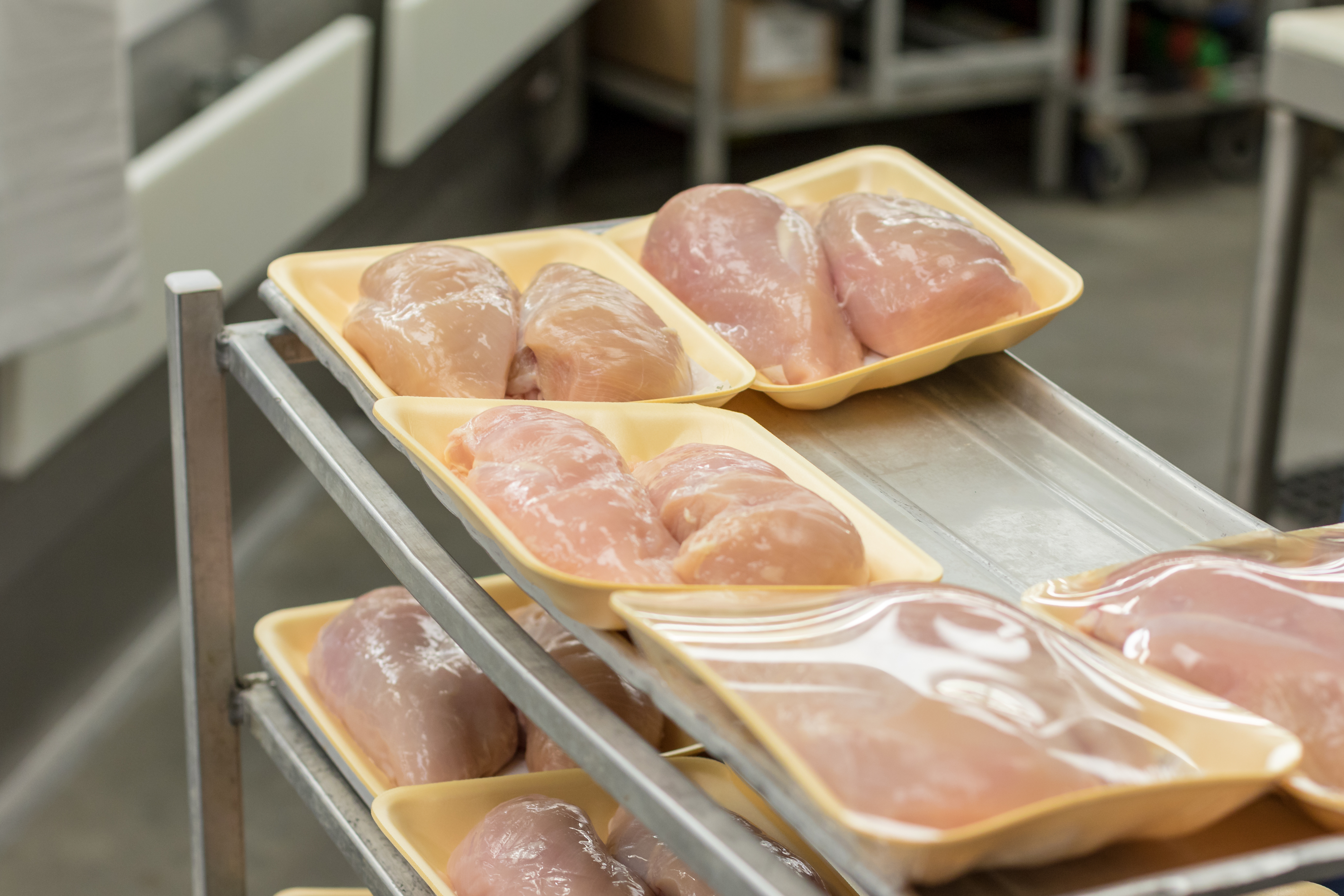 Chicken breasts sitting on a butcher's cart, waiting to be wrapped