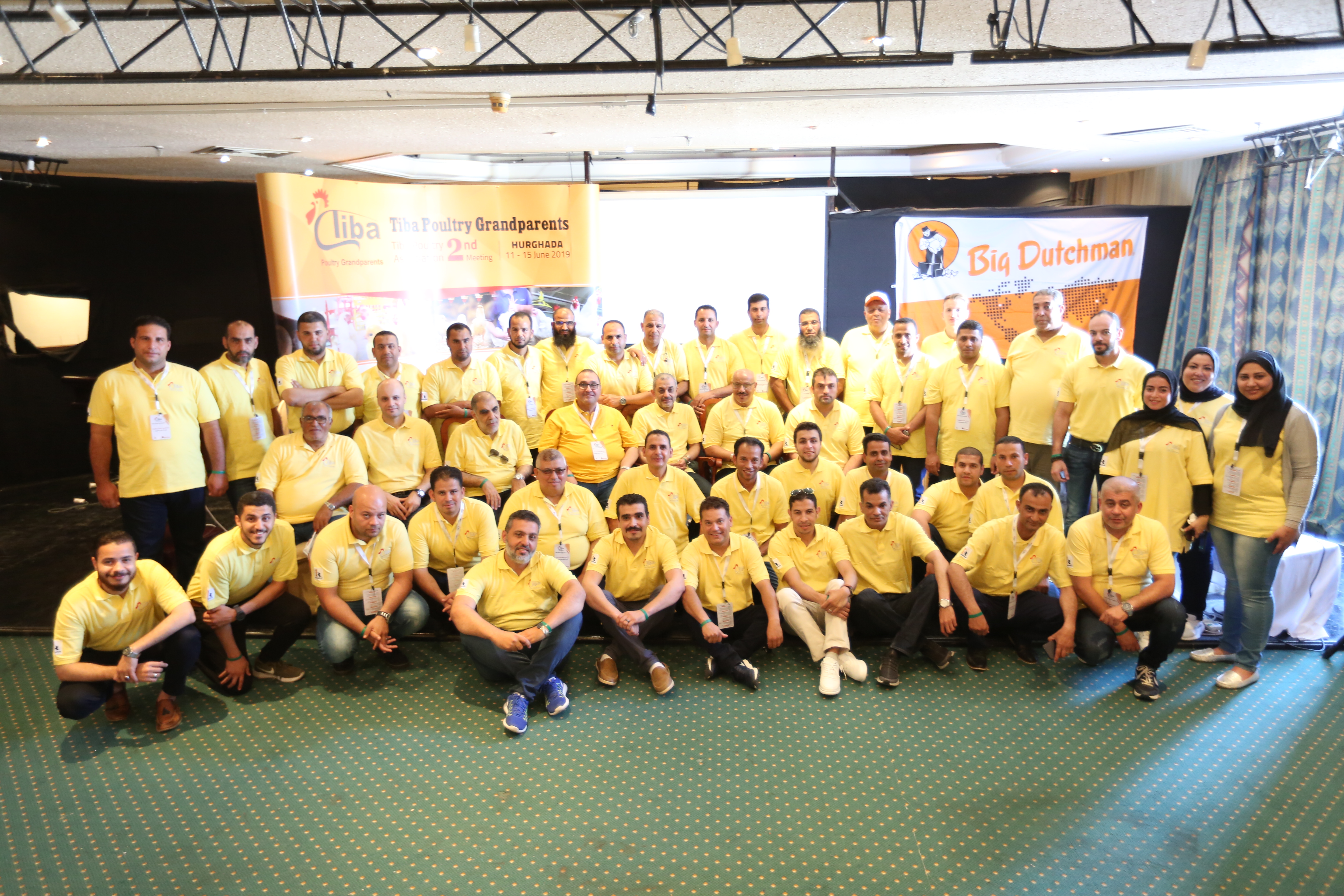 a group of people wearing yellow t-shirts line up for a photo