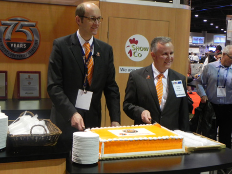 Bernd Meerphol, Big Dutchman CEO (l) and Clovis Rayzel, President of Big Dutchman, Inc (r), cut the anniversary cake during the 2013 IPPE show in Atlanta