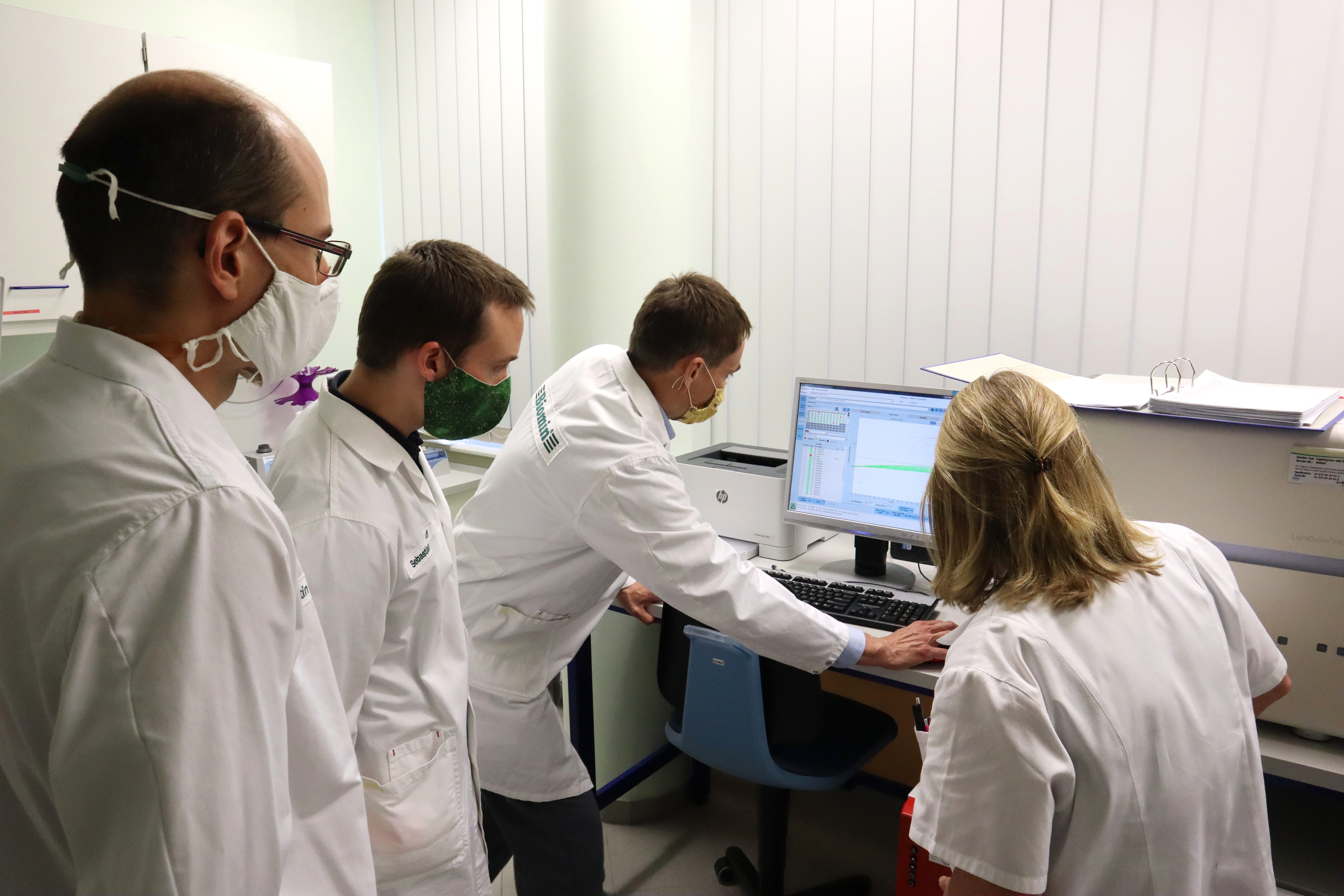 Researchers standing around a computer screen