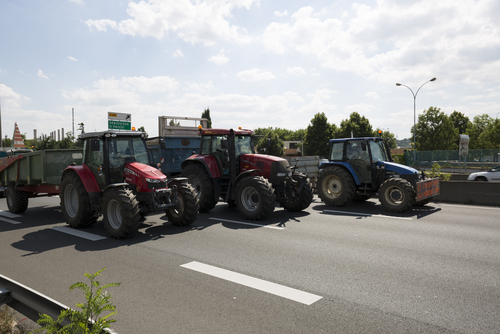 French farmers block roads, spray manure at public development